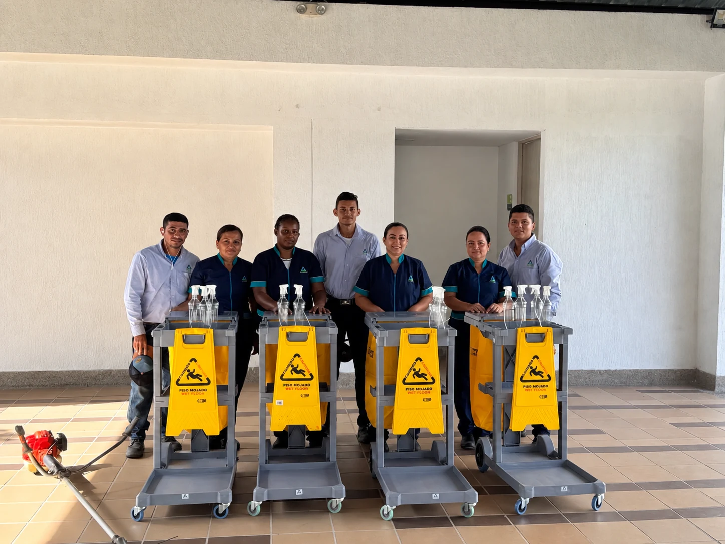 Siete integrantes del equipo de COASERV con uniformes, carros e implementos de trabajo